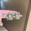 Close-up of gold flower stud earrings with green blue crystals and a central faux pearl - Gold