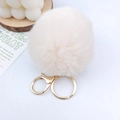 Nahaufnahme vom beigen Pelzimitat-Pompon Schlüsselanhänger mit goldenem Karabinerverschluss - 8cm Kaninchenpelz-Imitat-Ball / Gebrochenes Weiß