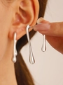 Irregular silver liquid teardrop earrings with a polished metallic finish on model - Silver Long Drop