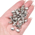 Detail van zilveren CCB-kralen voor DIY-sieraden maken vastgehouden in een hand - Boon 7x9mm (20 stuks/pak)