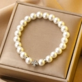 Baroque pearl bracelet with silver cross pendant on golden silk background - White Gold Pearl Rhinestone Cross Bracelet (A-1419)