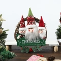 Detail von Weihnachtskranz mit Plüschfiguren und hölzernem Merry Christmas Schild - 2 Weihnachtsmann-Köpfe-Kranz