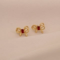 Golden double layer bow earrings with a square red gemstone on a soft pink background - Gold Bow Red Zirconia / Red
