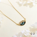 Detail of gold evil eye necklace with colorful zircon stones on textured background - Blue Eyelash Style (NE2255-C-2)