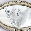 Detailed view of silver hollowed butterfly decorations on elegant gold-framed oval mirror - Style 2 / Set of 12 / Silver