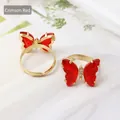 Elegant deep red butterfly ring with gold metal band and sparkling rhinestone accents - Red