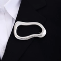 Broche ovalado irregular en plata pulida sobre una chaqueta negra con estilo elegante - X320-2 Plata