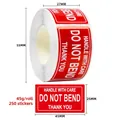 Macro detail of red fragile warning stickers roll with Do Not Bend text and handle with care - C125 (Red Multilingual Fragile)