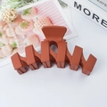 Reddish brown matte wavy claw clip for hair styling shown against a clean white background - Orange Red