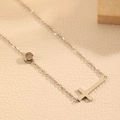 Détail d'un collier en acier inoxydable argenté avec pendentif diamant rond et croix - Collier Argent