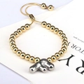 Adjustable golden beaded bracelet featuring a silver metallic letter F charm detail - Letter F