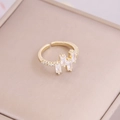 Close-up of 18K gold-plated ring featuring three rectangular zircons on a jewelry box - Adjustable Open / White