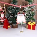 Detail eines Plüsch-Weihnachtsmanns mit rot-kariertem Hut und goldenen Glocken an den Beinen - Weihnachtsmann-Stil