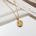 Macro detail of gold-plated bear pendant with sparkling zircon border on silk backdrop - Bear
