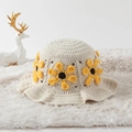Detail of hand-woven crochet bucket hat featuring a yellow sunflower on beige knit - One Size / Yellow Daisy White Base