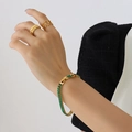 Elegant gold plated bracelet set with green rectangular zircon gemstones on model wrist - 19cm Bracelet Extension / Green