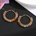 Detailansicht goldene Boho-Creolen mit bunten Natursteinperlen und Drahtumwicklung - Tigerauge-Muster Braun Orange