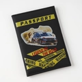 Detailed view of a black rally car design passport cover with warning tape patterns and text. - Black