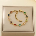 Pulsera dorada con gemas de colores en forma de gota sobre un joyero color champán - Pulsera de Gota de Agua Colorida (KB204111-SXSJ)