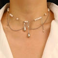 Layered pearl tassel choker necklace with cross pendant and crystals on a model - Layered Metal Pearl Drop Choker / Silver Necklace
