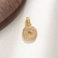 Macro view of a gold-plated circular pendant paved with sparkling zircon stones - Letter O