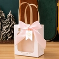 White gift bag with clear window, pink satin bow and Wedding Day tag on wooden desk - Beige + Wedding Tag