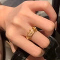 Vintage gold butterfly ring with pink shell flowers and pearls worn on a finger - Retro Floral