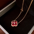 Nahaufnahme von vierblättrigem Blumenanhänger mit roten Zirkonen und feiner Goldkette - Gold