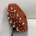 Detail of caramel wool beret featuring elegant faux pearl and rhinestone embellishments - Caramel color