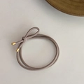 Detailed close-up of high-elastic taupe hair tie with polished gold metal fastener - Light Gray
