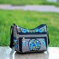 Detailed close-up of intricate floral embroidery on black canvas crossbody bag zippers - Money Tree Blue