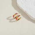 Close-up of colorful heart-shaped zircon earrings on a textured stone display - Colorful Heart Zirconia Hoop Earrings (ES2282-20MM)