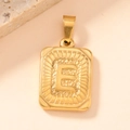 Macro view of gold rectangular pendant with embossed letter E and vintage texture - Letter E