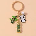 Dettaglio portachiavi dorato con ciondolo panda, foglia di bambù e pietra di giada - Panda di Bambù