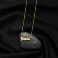 Macro detail of Gemini pendant necklace on black velvet with smooth pebble stone decoration - Gemini Gold
