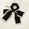 Detail of elegant black ribbon hair tie with white piping and long flowing streamers - Short Knotted Black (Wrapped)