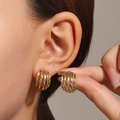 Elegant multi-layered gold twisted hoop earrings showing vintage texture on a model - 14K Gold Plated Multilayer Twisted Style (3983)