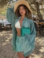 Detalle de camisa verde de lentejuelas con puños de plumas y falda a juego en la playa - S / Verde
