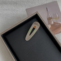 Detail of drop-shaped marble texture hair clip with elegant cutout design and gold hardware - Shell Mermaid Hollow Teardrop