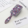 Colorful sugar skull and rose pattern anti-static massage hairbrush in a lifestyle setting - Four Skulls