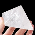 Hand holding a natural white crystal pyramid with internal ice cracks on black background - 9cm