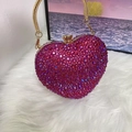 Close-up of pink rhinestone heart-shaped evening bag with golden chain and clasp - Fuchsia AB