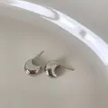 Boucles d'oreilles lune en argent poli présentées dans une coupelle en céramique - Boucles d'Oreilles Clous Grain d'Argent