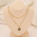 Détail d'un collier double rang doré avec chaîne serpent et pendentif soleil noir sur buste - 6# Soleil Rond