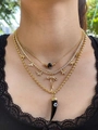 Dettaglio macro della collana a strati in oro 18k con farfalla, corno nero e occhio - Set di Collane a Strati con Farfalla e Occhio del Diavolo Corno