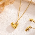 Goldene Herz-Halskette mit bunten Zirkonsteinen auf weißem Steinhintergrund - Gold Herz Zirkonia Stil