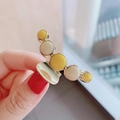 Detailed view of large gold metal hair claw clip with yellow and white pearl bead accents - Bright Yellow Marble