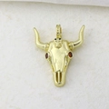 Macro view of a golden bull skull pendant featuring red zircon eyes and punk style - Gold Bull Skull