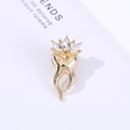 Macro shot of creative tooth shaped brooch with polished gold plating and sparkling crystals - Crown Tooth/Gold