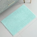 Absorbent light green chenille rectangle bath mat on grey tiles in modern bathroom - Cyan